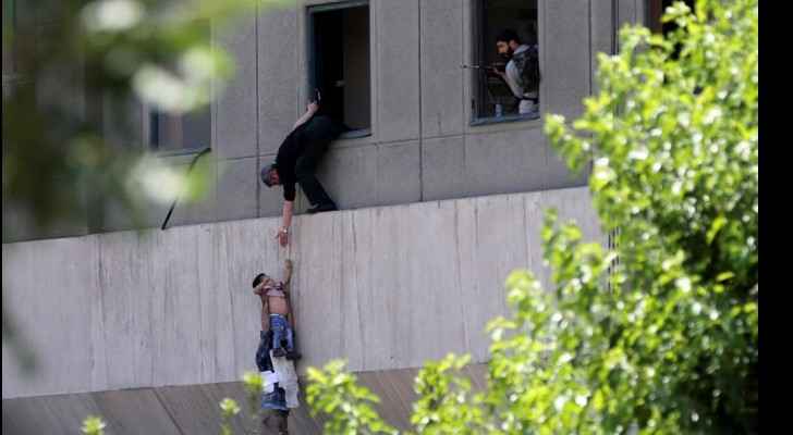 A boy is evacuated during an attack on the Iranian parliament in central Tehran on June 7