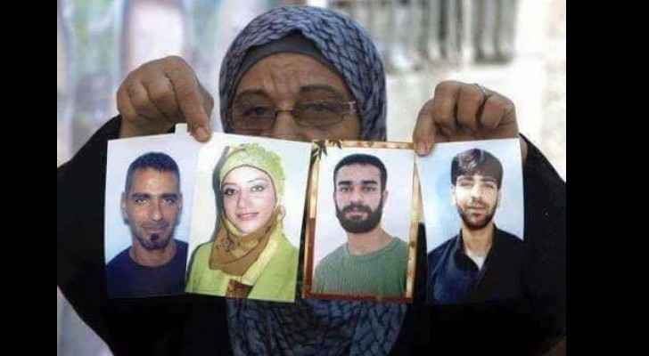 Shereen Al Issawi's mother, carrying images for her detained children. (Facebook)