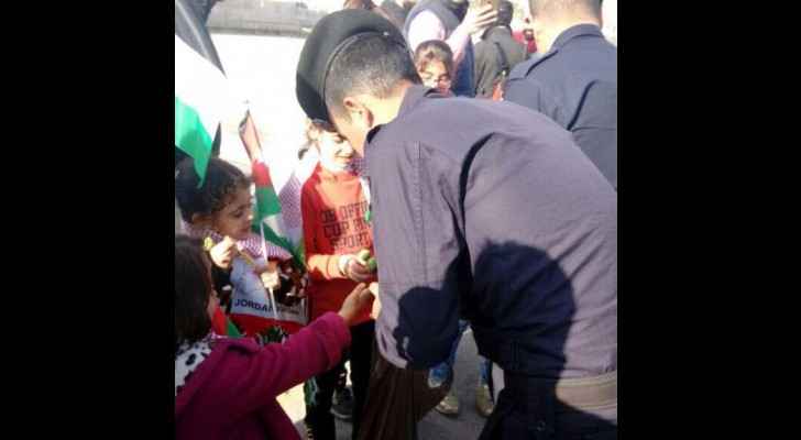 A policeman hands out candy to orphans in Amman. (Roya)
