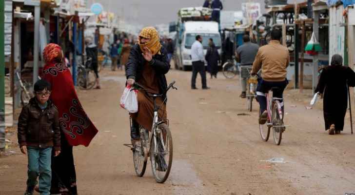 Syrian refugees ride bicycles during rainy weather at the Zaatari refugee camp in the Jordanian city of Mafraq. (VOA News)