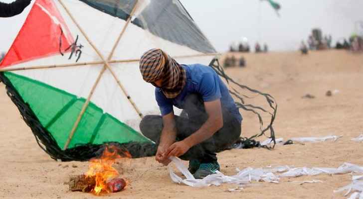 Palestinian rioter prepares incendiary kite on Gaza border (AFP)
