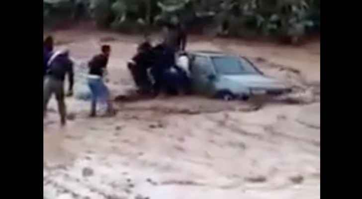 Rescue teams save passengers in a car that was swept away by floods in Madaba on Friday, November 9, 2018. (Roya)