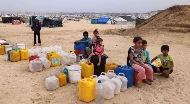 Displaced Palestinian children wait by containers for water supply at their tent camp in Rafah, south Gaza. (April 26, 2024) (Photo: AFP) 
