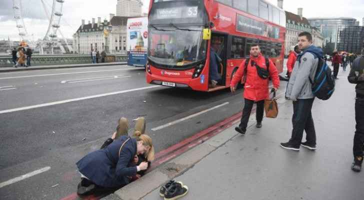 A woman assists an injured person on Westminster Bridge in London after Saturday's terrorist attack. 