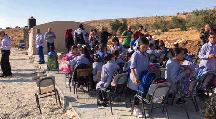 Students study outside after their school was demolished. (Photo: Quds Network) 