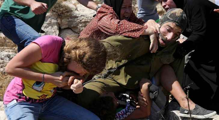 Ahed al-tamimi trying to save her brother from being arrested by Israeli soldiers two years ago (NBC)