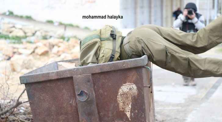 It is unknown how or why the Israeli soldier fell into the trash container. (Mohammad Halayka)