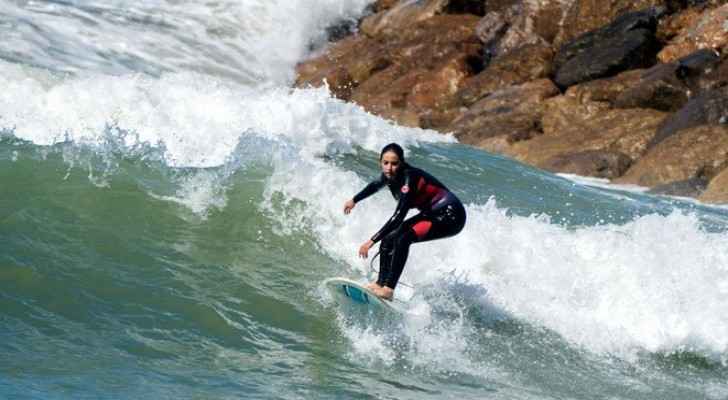 Meriem, a 29-year-old Moroccan engineer and surfer, surfs off the coast of Rabat on April 1, 2018. (AFP)