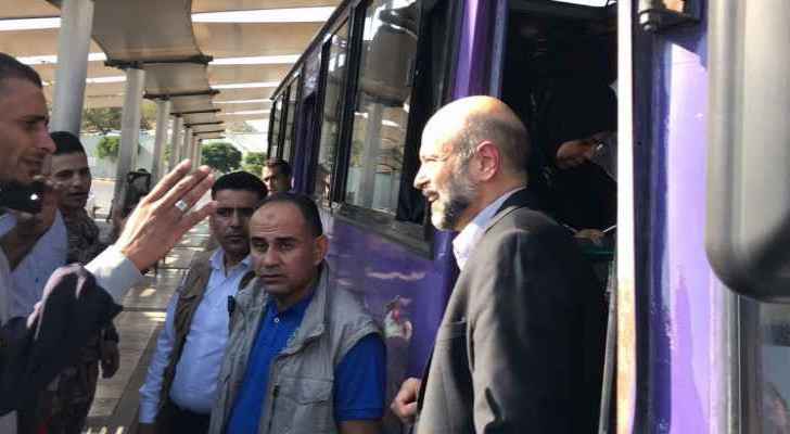 Razzaz rides a bus in Tabarbour during his surprise visit. (Roya)