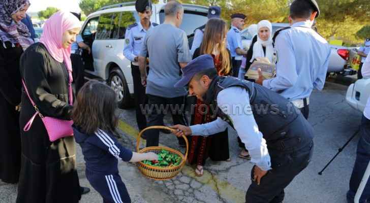 A police officer hands out candy to a little girl in Amman on Eid Al Adha. (Roya)