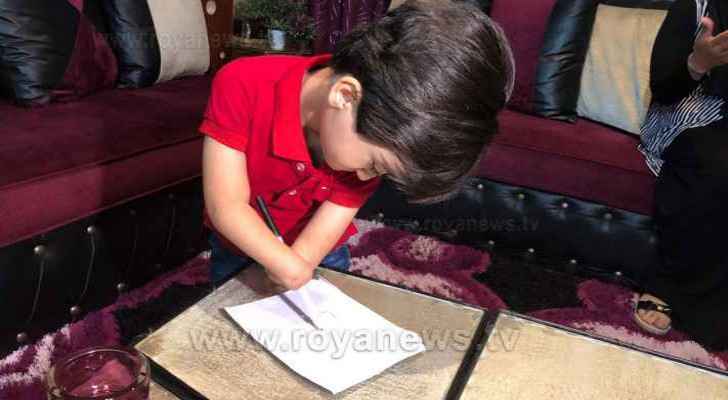 Ruwaid writes on a piece of paper during his interview with Roya. (Roya)