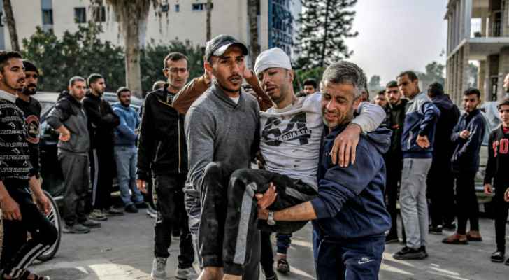 Palestinians carrying an injured individual. (Credit: AFP)