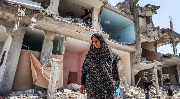 Woman walks through the rubble of a collapsed building in Maghazi camp in Central Gaza  (April 15, 2024) (Photo: AFP) 