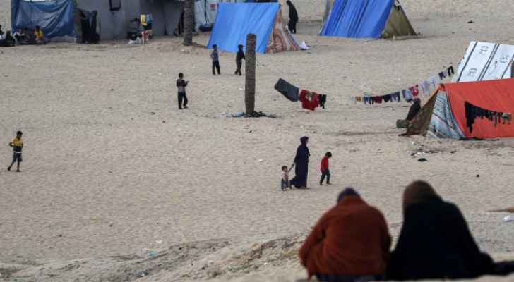 Displaced Palestinians sit near tents in Rafah, south of Gaza Strip