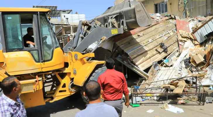 Bulldozer removing some of the sidewalk encroachments  in Al-Wehdat camp